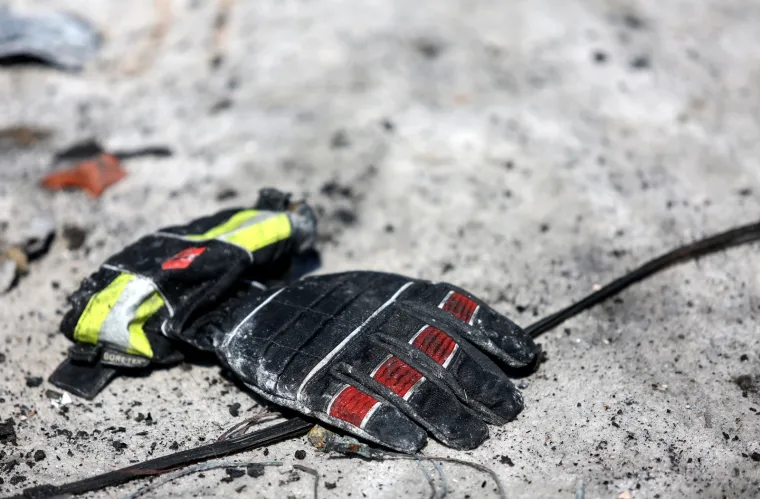 Ispred kuće u kojoj je kobni požar oduzeo život mladom vatrogascu, upaljene svijeće. Vatrogasna rukavica ispred mjesta nesreće