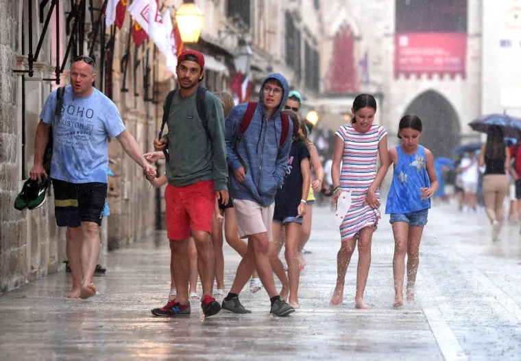 Stradun je pod vodom, no to nije omelo turiste: Dobro se zabavljaju i trče bosi