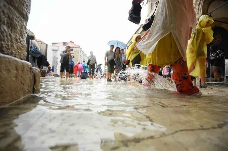 Stradun je pod vodom, no to nije omelo turiste: Dobro se zabavljaju i trče bosi