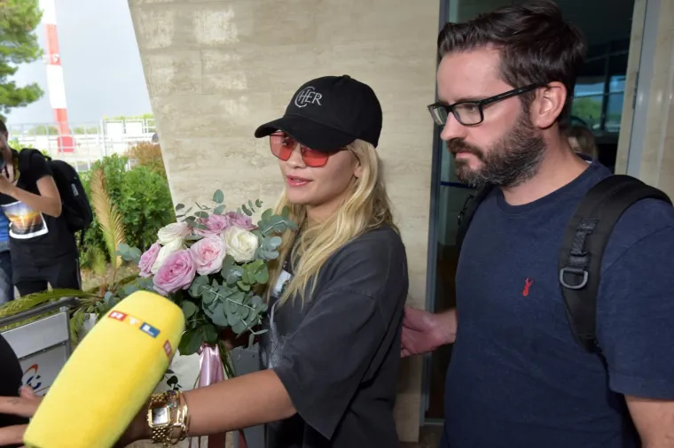 Albanskoj zvijezdi koje će večeras nastupiti u Zadru iz Turističke su zajednice poklonili cvijeće i bocu Maraskina. Rita Ora je poručila kako je sretna &scaron;to je ponovno u Zadru te da je iznimno uzbuđena. Nije imala nikakvih specijalnih zahtjeva osim puno vode, bocu Gina i tekile.