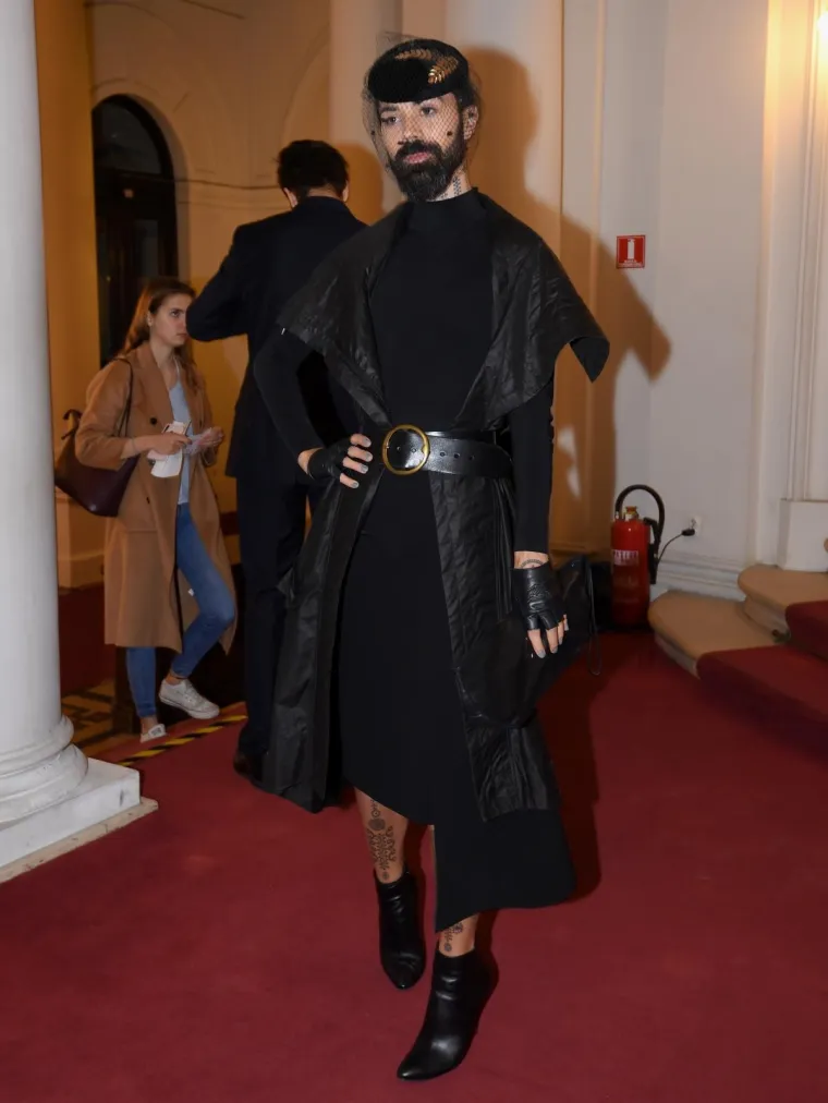Predstava je privukla brojna poznata lica. Među okupljenima, bio je i glazbenik Božo Vrećo, koji se pojavio u elegantnom crnom izdanju. Vrećo je odjenuo crnu haljinu koju je u struku stegnuo remenom, a outfit je začinio šeširom s mrežicom i dva zlatna detalja.
