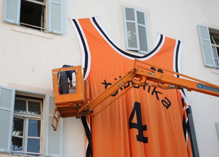 Na zgradi Gradske uprave postavljen je dres Dražena Petrovića dimenzija 5 x 7 metara, a dizajnirala ga je i sa&scaron;ila Karmen Herceg povodom njegovog 55. rođendana.Photo: Du&scaron;ko Jaramaz/PIXSELL
