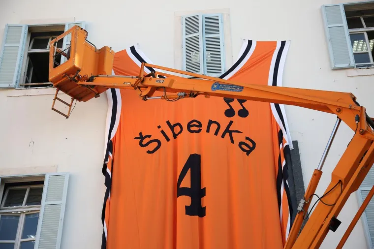 Na zgradi Gradske uprave postavljen je dres Dražena Petrovića dimenzija 5 x 7 metara, a dizajnirala ga je i sa&scaron;ila Karmen Herceg povodom njegovog 55. rođendana.Photo: Du&scaron;ko Jaramaz/PIXSELL