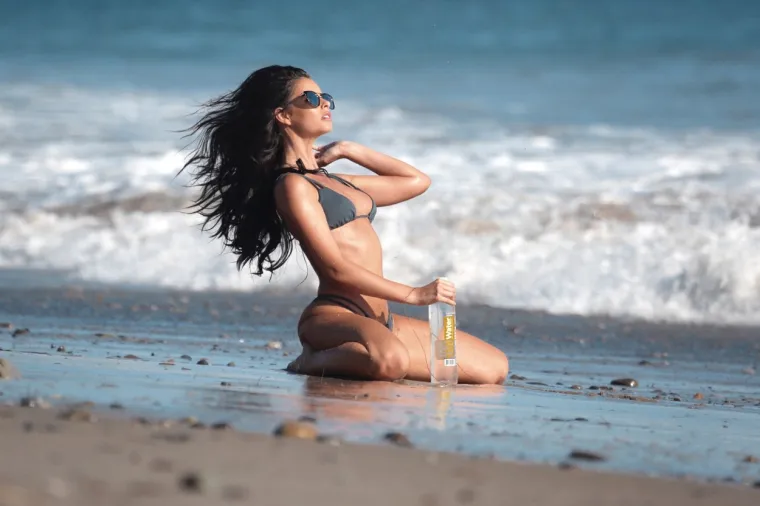 IZAZOVNE POZE U PLIĆAKU: Manekenka privlačila poglede na snimanju; oskudne krpice jedva su zauzdale njezine bujne obline