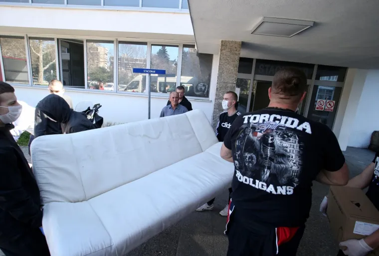 17.03.2020.,Split - Svi zavodi, klinike i odjeli s lokaliteta bolnice Krizine krenuli su u svoju, prvu u povijesti, selidbu u bolnicu Firule u Splitu, a svoj obol borbi protiv korona virusa dala je i Torcida.
Na mjestu dogadjaja pojavili su se i momci iz Torcide te pomazu da se posao obavi sto prije, a treba istaknuti da su sami poduzeli zastitne mjere i nabavili maske i rukavice
Photo: Ivo Cagalj/PIXSELL