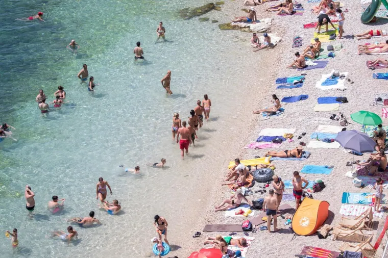 28.07.2020., Rijeka - Ljudi na plaži uživaju u sunčanju i kupanju.