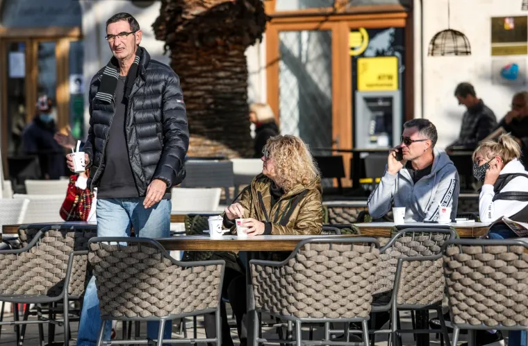 Građani s kavom za van sjeli na terase zatvorenih lokala i uživali u suncu na rivi. Photo: Ivo Cagalj/PIXSELL
