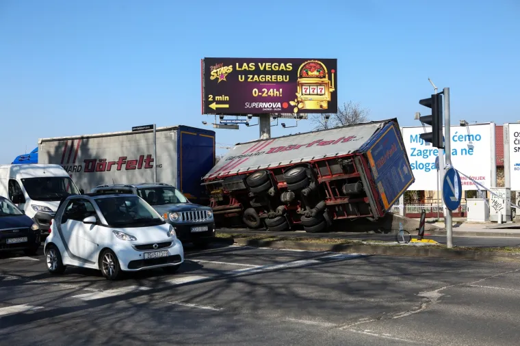 Na križanju Buzinskog prilaza i Avenije Većeslava Holjevca oko 13 sati do&scaron;lo je do prevrtanja kabine teretnog vozila, javlja policija. Prilikom pada na bočnu stranu kabine vozila do&scaron;lo je do o&scaron;tećenja stupa ulične rasvjete.