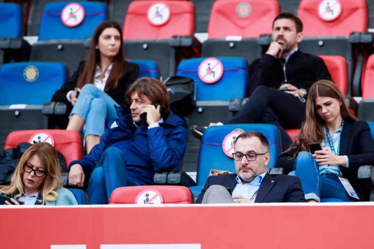 Naravno, član Uprave Dinama Krešimir Antolić predvodi delegaciju iz Zagreba. Bad Blue Boysi i veliki dio općenitog navijačkog puka Plavih ne slažu se s njegovom ulogom, vodstvom i načinom na koji upravlja klubom, u izostanku ali pod stalnom prismotrom gospode iz Međugorja, posebno Zdravka Mamića s kojim je u svakodnevnom telefonskom kontaktu i sluša upute.