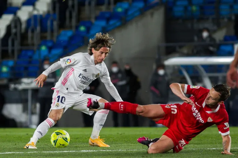 U derbiju 35. kola Primere Real i Sevilla su odigrali 2-2, a "Kraljevski klub" je od poraza spasio autogol u 94. minuti, dok je gol za Sevillu polučio Ivan Rakitić.   Sevilla je povela u 22. minuti golom Fernanda na asistenciju Rakitića, a Real je izjednačio u 67. minuti preko Asensia na dodavanje Kroosa.   Rakitić je iz penala opet doveo Andalužane u vodstvo u 78. minuti i činilo se da će to biti konačan rezultat sve dok u četvrtoj minuti sudačke nadoknade Kroos je pucao, a loptu u gol skrenuo igrač Seville Carlos.  Luka Modrić je igrao do 66. minute, a Rakitić do 88.   Ovaj ishod je tri kola prije kraja ostavio Atletico na vrhu s 77 bodova, Real i Barcelona imaju po 75 bodova, a Sevilla 71.