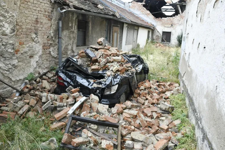 No, vjerojatno nije vidio ovaj Mercedes koji još od potresa stoji u dvorištu uništene kuće zatrpan ciglama i šutom. Da ondje nitko nije zašao dokazuje i visoka trava i korov. 