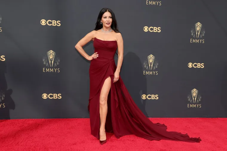 U nedjelju navečer održana je dodjela glavne televizijske nagrade Emmy, a apsolutni pobjednici večeri bile su tri serije - drama &apos;The Crown&apos;, komedija &apos;Ted Lasso&apos; i miniserija &apos;The Queen&apos;s Gambit&apos;. Catherine Zeta-Jones došla je kao pratnja suprugu Michaelu Douglasu, koji je bio nominiran u kategoriji glavnog glumca u &apos;The Kominsky Method.&apos; 51-godišnja glumica svojom je zanosnom pojavom u haljini boje burgundija zasjenila brojne mlađe kolegice.