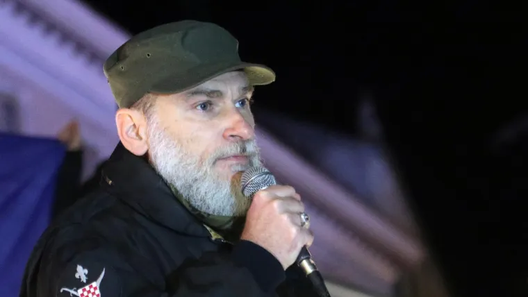 DŽIHADI MARKO 

Nakon upada Trumpovih pristaša u američki Kongres, koji su početkom 2021. pokušali spriječiti verifikaciju izborne pobjede Joea Bidena te usput izazvali krvave nerede, svijet je obišla slika Jacoba Chansleyja, jednog od vođa prosvjeda, kojeg su tamošnji mediji prozvali &quot;QAnon Šamanom&quot;. Lica obojenog ratničkim bojama, odjevenog u krzno i s bizonovim rogovima na glavi Chansley je postao jedna od bizarnijih lica godine. U Hrvatskoj se, na velikom prosvjedu u Zagrebu protiv covid potvrda potkraj studenoga, u prvi plan isturio Marko Francišković, desničarski aktivist koji je prešao na islam i dobio nadimak Džihadi Marko s idejom da se Hrvatska uredi prema teokratskom modelu. &quot;Prestanite biti ovce i postanite lavovi. Božji lavovi su tu, dignite se i vičite!&quot;, poručio je okupljenima. Kasnije je s pristašama bezuspješno pokušao ući u zgradu HRT-a želeći uživo u programu iznijeti svoje ideje. Kada je uhićen i pritvoren zbog poticanja na terorizam, tvrdio je da je samo &quot;iznosio propagandne ideje s vizualnim efektima&quot;. I onaj &quot;Qanon Šaman&quot; iz Washingtona iz zatvora je kasnije poručio da ga je Trump prevario i upleo u mrežu laži.  
