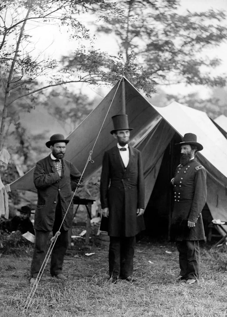 6. &apos;Predsjednik Lincoln u posjeti Antietamu&apos;, Alexander Gardner (1862.): Građanski rat je bio najsmrtonosniji u američkoj povijesti, a njegova najkrvavija bitka se dogodila 1862. U jednodnevnoj bitci kod Antietama je bilo 23.000 zajedničkih žrtava Unije i Konfederacije, s 3600 ubijenih. Dva tjedna kasnije, predsjednik Lincoln je posjetio mjesto bojnog polja kako bi promatrao pokolj i odao počast žrtvama s obje strane.

Na fotografiji general John McClernand stoji s Lincolnove lijeve strane. McClernand je bio kongresmen iz Illinoisa i raniji Lincolnov politički suparnik, kojeg je Lincoln uvjerio da se pridruži vojsci Unije. S Lincolnove desne strane je Allan Pinkerton, koji je 1850. osnovao kontroverznu detektivsku agenciju Pinkerton. Tijekom rata Pinkerton je bio Lincolnov neslužbeni šef tajne službe i ministar vojne obavještajne službe. Njegove pogreške u ovoj ulozi pomogle su produžiti rat.

Ova fotografija je bila jedna od 25 koje je fotograf Alexander Gardner snimio tog dana. Gardner je bio zaposlenik poznatog fotografa iz građanskog rata Mathewa Bradyja, a na kraju je dobio redoviti zadatak u stožeru generala Georgea McClellana, pod počasnim činom kapetana.

