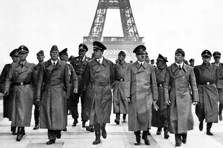 8. &apos;Hitler obilazi Eiffelov toranj&apos;, Heinrich Hoffman (1940.): Kao i mnoge slavne osobe, Adolf Hitler je putovao s pratnjom u kojoj je bio i njegov osobni fotograf, Heinrich Hoffman.

Hitler je pažljivo kontrolirao svoj osobni imidž, a kako se Drugi svjetski rat nastavljao, postajao je sve više paranoičan. Hoffman je bio s Hitlerom od njegovih ranih dana kao političar u Münchenu, a do 1940. je bio jedina osoba koja je smjela fotografirati Hitlera.

Hoffman je bio ondje 14. lipnja, kada su Hitler i mnogi njegovi vrhunski generali pozirali za fotografije ispred Eiffelovog tornja i drugih spomenika u Parizu. Hvalisava serija fotografija postala je snažan simbol rane pobjede Njemačke u ratu.
