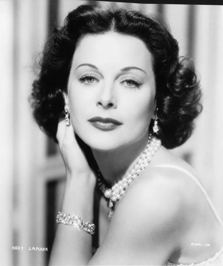 Hedy Lamarr potječe iz bečke židovske obitelji. Njen otac Emil Kiesler je bio direktor banke, a majka Gertrud bila je pijanistkinja. Već u svom trećem filmu &quot;Mi ne trebamo novac&quot; s Heinzom Rihmannom i Hansom Moserom imala je glavnu ulogu. Čehoslovački film &quot;Ekstaza&quot; iz 1933., u kojem je njezina supruga glumio Zvonimir Rogoz, zbog nekih je slobodnih i erotskih scena izazvao skandal, ali više radi izraza njezina lica u prvom planu dok glumi orgazam, nego radi snimka u kojem gola trči kroz šumu (to je bio prvi integralni akt u povijesti umjetničke kinematografije). Udala se 10. kolovoza 1933. za bogata bečkog industrijalca Fritza Mandla, koji je bio veoma konzervativan te joj je zabranio snimati nove filmove. Uočivši jačanje fašizma u Austriji i nacističke okupacije njene domovine, bježi 1937. i iz zemlje i od svoga supruga u Pariz a odatle u London. Veliki filmski mogul Louis B. Mayer otkriva lijepu glumicu i daje joj ugovor za MGM. U to vrijeme mijenja svoje pravo ime u umjetničko. Hedy odlazi u SAD i biva hvaljena kao nasljednica Marlene Dietrich i Grete Garbo iako se njezino glumačko znanje ne može usporediti s njenom ljepotom. Najveći komercijalni uspjeh postigla je ulogom u filmu &quot;Samson i Dalila&quot;. Hedy Lamarr bila je i inovatorica u području bežičnih komunikacija. Kao otvorena protivnica fašističke Njemačke u Drugom svjetskom ratu prijavila je 1942. patent upravljanja torpeda izmjenjivim frekvencijama koje bi stoga tada bilo nemoguće predvidjeti i omesti. Iako Mornarica SAD-a taj izum nije iskoristila, ta se tehnologija, bez koje bi bio nemoguć WiFi, i danas koristi za mobilne telefone i za upravljanje frekvencijama. Premda za života nije dobila zaradu i zahvalu za svoj izum, smatraju je velikom inovatoricom, pa se međunarodni Dan izumitelja slavi 9. studenoga, na njezin rođendan.