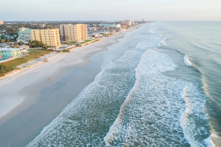 2. New Smyrna Beach u Floridi, SAD također je pri vrhu popisa opasnih plaža kojima haraju morski psi. New Smyrna popularna je plaža pod državnom upravom s puno parkinga. Ima velik broj surfera i plivača u oceanu tijekom cijele godine, s prosječno 9 ugriza morskih pasa godišnje. Svake godine u određeno vrijeme jato riba pliva prema sjeveru, duž obale Floride, a u toj godišnjoj migraciji, koja uključuje milijune životinja, slijedi ih mnoštvo grabežljivaca, među kojima su morske ptice i morski psi. Na sreću, većina morskih pasa koji prate jata riba u New Smyrni imaju 2 metra ili manje, s velikom većinom ugriza koji nisu smrtonosni, za razliku od ljudskih susreta s većim morskim psima drugdje.