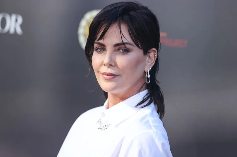 Nova frizura Charlize Theron je slojevita, uz pixie rez sa strane i stilizirana u njezin uobičajeni kosi bob. Također je nosila svježe ošišane tanke šiške.