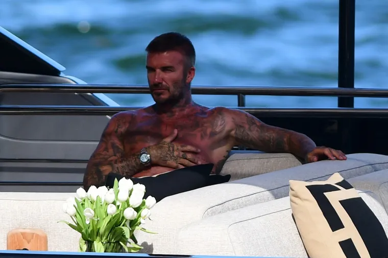 David Beckham pokazao svoj preplanuli torzo na jahti: Dok ga je usluživala zgodna žena nije skidao osmijeh s lica