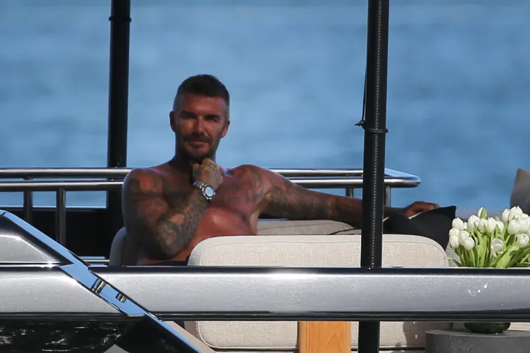 David Beckham pokazao svoj preplanuli torzo na jahti: Dok ga je usluživala zgodna žena nije skidao osmijeh s lica