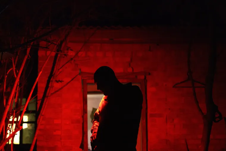 Ukrajinski vojnik razgovara s kolegama iz svoje jedinice ispred njihovih kreveta u selu u regiji Donjeck (kolovoz 2022.)