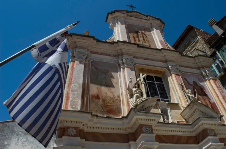 Plavo-bijela zastava viri gotovo na svakom ćošku ovog malog, idiličnog mjesta uz granicu s Francuskom. S većine građevina promatraju vas poglavari oslikani na portretima, a turiste salutiranjem dočekuje državna garda s plavim beretkama. 