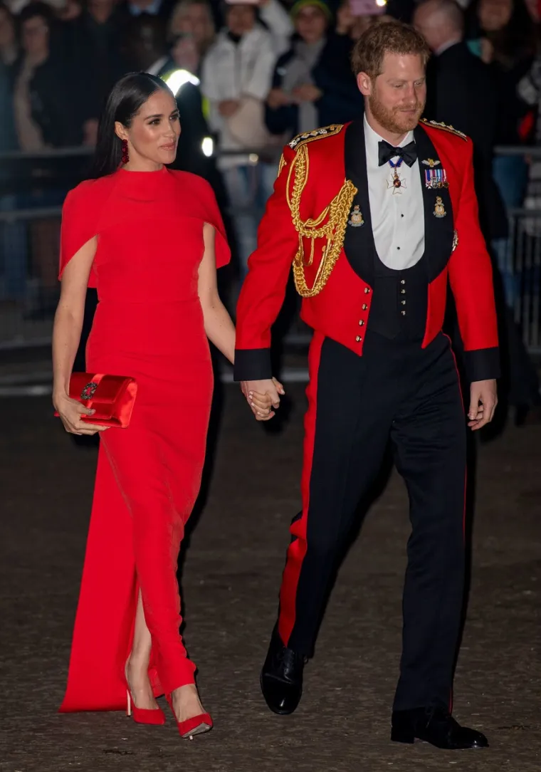 2020.: Meghan je na glazbenom festivalu Mountbatten nosila haljinu s crvenim plaštom britanskog brenda Safiyaa. Ta je prigoda također obilježila njezin posljednji večernji događaj kao zaposlenog člana kraljevske obitelji. &quot;Bio je to trenutak koji će ući u povijest&quot;, rekla je osnivačica Safiyae, Daniela Karnuts, za People. 