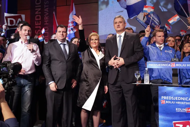 
Odjevena u crno-bijeli komplet, Kolinda je u svojem stožeru proslavila pobjedu &scaron;ampanjcem, tortom i pjesmom, a uz nju je cijelo vrijeme bio suprug Jakov Kitarović. 