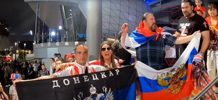 Šajkače, kokarde, ruske zastave i slovo Z. Svega je bilo noćas u Melbourneu na Australian Openu po našem vremenu. Na sliki možete vidjeti dvojicu likova koji daju podršku Rusiji, agresoru na Ukrajinu. Tip gore desno u crnoj majici ima simbol Z. Majica je, inače, napravljena sa svrhom pružanja podrške Rusiji u ratu protiv Ukrajinaca. Inače, ovo je trenutak nakon meča Đokovića i Rubljova u četvrtfinalu turnira, na stepenicama kad se ulazi na Road Laver Arenu. Policija je nakon ovog uhitila 4 Srba, pretpostavlja se i ovog desno na slici i gospodina s ruskom zastavom. 