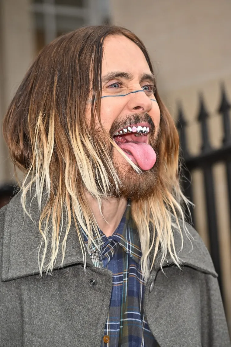 Jared Leto je na pariški Tjedan mode stigao u još jednoj simpatičnoj opravici. Glumac i glazbenik nosio je pritom i &quot;metalne zube&quot; s roza gumicama te je kombinirao suknju, kaput i različite košulje s visokim platformama...