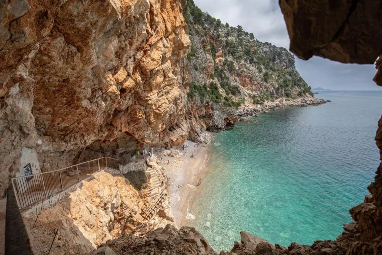 Ova skrovita plaža često se nalazi na popisima najboljih europskih destinacija zahvaljujući svom jedinstvenom izgledu jer se doslovno nalazi ispod visokih stijena, piše Dubrovački Dnevnik.