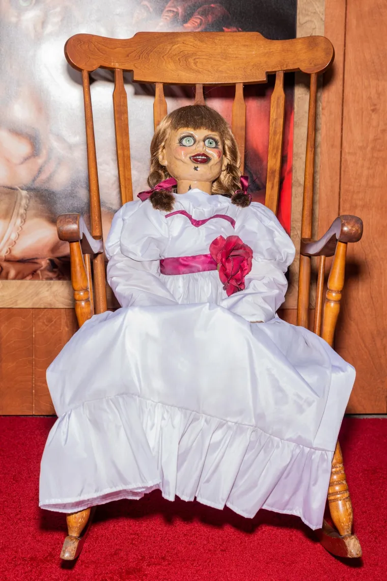 ANNABELLE: Situacija je eskalirala kada je prijatelj cimerice navodno napadnut u stanu, zadobivši neobjašnjive ogrebotine na prsima. Djevojke su tada kontaktirale poznate istražitelje paranormalnog, Eda i Lorraine Warren, koji su zaključili da je lutka opsjednuta demonom. Annabelle je od tada zatvorena u posebno blagoslovljenu vitrinu u okultnom muzeju Warrenovih. 