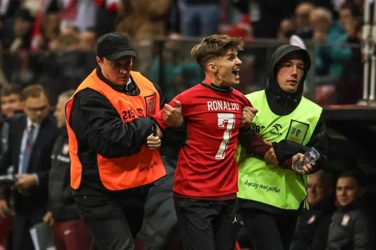 Za&scaron;titari odvode navijača koji je upao na teren kako bi dobio sliku s Ronaldom za vrijeme utakmice Poljske i Portugala u Ligi nacija 