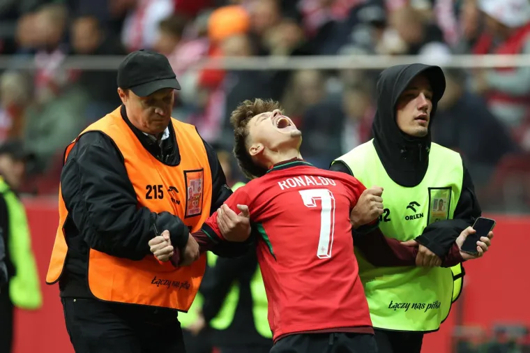 Za&scaron;titari odvode navijača koji je upao na teren kako bi dobio sliku s Ronaldom za vrijeme utakmice Poljske i Portugala u Ligi nacija 