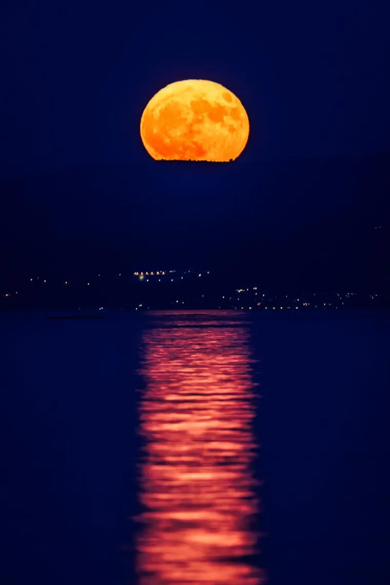 Atmosferska iluzija dodatno pojačava ovaj efekt. Kada Mjesec izlazi ili zalazi, on se pojavljuje blizu horizonta, a naš mozak, u usporedbi s objektima na horizontu (poput stabala ili zgrada), doživljava Mjesec većim nego kada je visoko na nebu. Ovo je poznato kao Mjesečeva iluzija i dodatno pridonosi dramatičnom dojmu veličine supermjeseca.