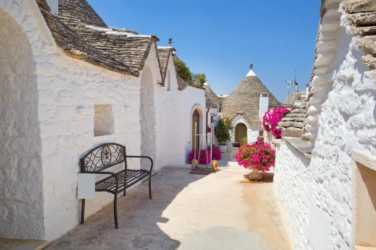 ALBEROBELLO (ITALIJA) - Alberobello je čaroban gradić u talijanskoj pokrajini Apuliji, poznat po svojim jedinstvenim kućicama zvanim trulli. Ove karakteristične građevine, sagrađene od kamena i prepoznatljive po svojim stožastim, suhozidnim krovovima, izgledaju kao da su izvučene iz bajke. Trulli su građeni bez maltera, a mnoge kućice ukrašene su simbolima koji imaju zaštitničku ili spiritualnu ulogu. Zbog svoje arhitektonske vrijednosti i očuvanosti, Alberobello je upisan na UNESCO-ov popis svjetske baštine. 