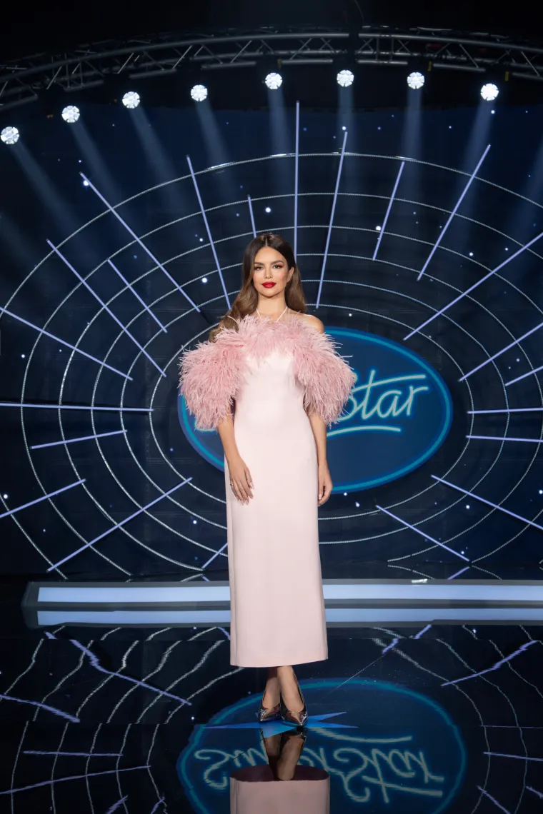 Severina ovdje nosi elegantnu dugu haljinu u nježnoj ružičastoj nijansi koja odiše glamuroznim šarmom starog Hollywooda. Haljina je jednostavnog kroja, ali efekat postaje naglašen dodatak raskošnih, mekanih perja na ramenima, koja daju volumen i teksturu cijeloj kombinaciji. Cipele su u metalik tonu, što se savršeno uklapa s nježnom ružičastom nijansom haljine i dodaje moderan kontrast ovom klasičnom izgledu. 