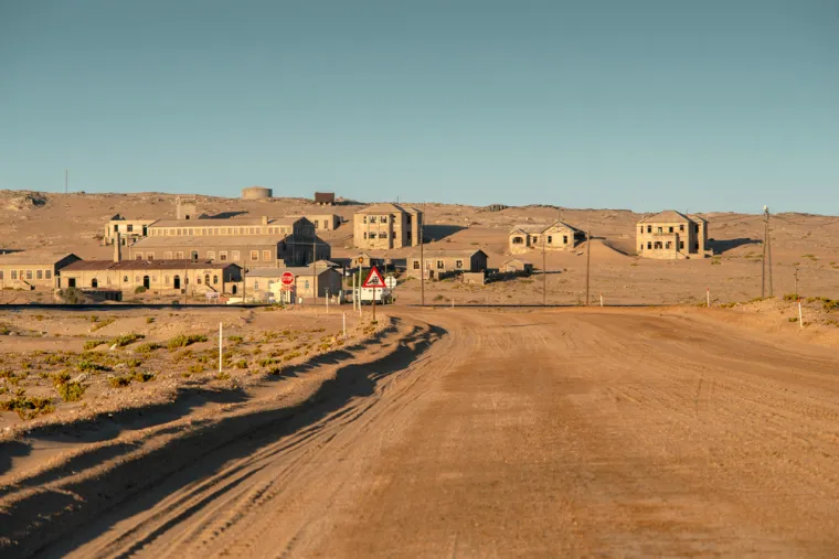 KOLMANSKOP (NAMIBIJA) - nekada je bio bogati rudarski grad u pustinji Namib. Osnovan 1908. godine nakon otkrića dijamanata, grad je doživio procvat u ranom 20. stoljeću. Međutim, kako su se zalihe dijamanata iscrpile, stanovnici su počeli napuštati grad 1950-ih. Danas pješčane dine polako prekrivaju napuštene zgrade, stvarajući nadrealan prizor.