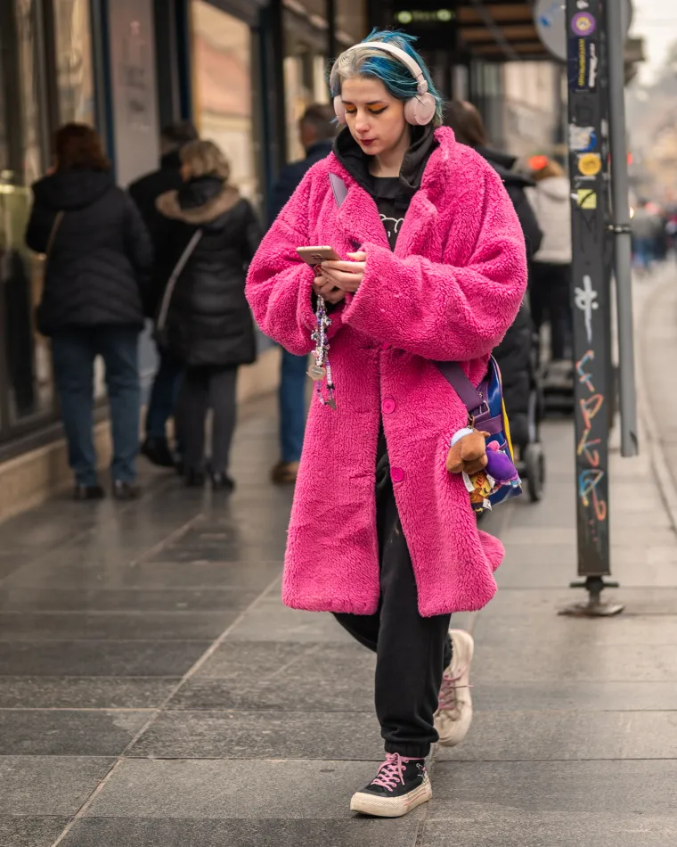Jedna od najupečatljivih kombinacija koja je zapala za oko ne samo fotografu, nego i brojnim prolaznicima, bila je upravo ova. Kaput jarko ružičaste boje uparen s Converse tenisicama od kojih je svaka različite boje uz šareni ruksak i crnu trenirku isticao se među gomilom koja je je nosila tipično zimske boje. Djevojka je outfit upotpunila crnim eyelinerom te žutim i narančastim sjenilom.