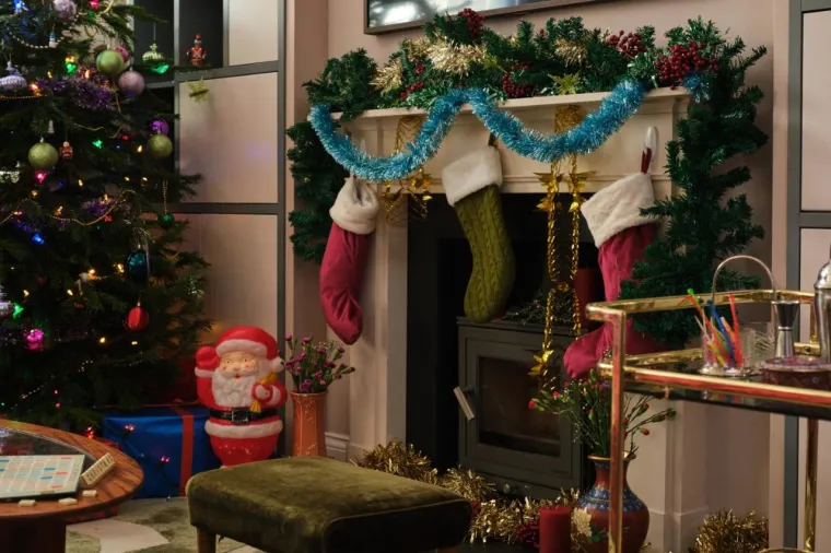 Također, u kutu sobe smjestio se starinski kamin, a Iznad njega, s pažljivo odabranim detaljima, vise božićne štrikane čarape u retro stilu. Ispred njega, nalazi se i maslinasto zeleni tabure s mekanim presvlakama, savršeno mjesto za opuštanje dok uživate u toplini vatre.