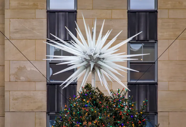 Na samom vrhu ovog veličanstvenog drvca nalazi se prava zvijezda atrakcija - Swarovski kristalna zvijezda, pravo remek-djelo moderne umjetnosti i inženjerstva. Ova fascinantna kreacija, teška nevjerojatnih 400 kilograma, sastoji se od čak tri milijuna precizno izbrušenih kristala koji hvataju i reflektiraju svjetlost na tisuće načina.
