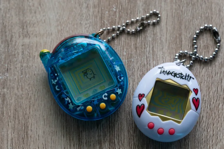 TAMAGOTCHI - Bio jedan od najtraženijih i najomiljenijih poklona 90-ih godina, koji je djecu diljem svijeta upoznao s konceptom digitalnih ljubimaca. Ovaj mali, jajoliki uređaj, sadržavao je samo nekoliko tipki i pikselizirani ekran, a korisnicima je omogućavao da brinu o svom virtualnom ljubimcu – hranili su ga, igrali se s njim, čistili iza njega i pazili da ostane sretan. 