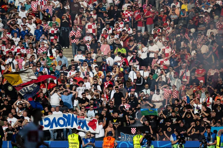 Hrvatske navijačke grupe, posebno BBB i Torcida, vratile su se na utakmice Vatrenih i osvježile atmosferu kad igra jedina nam Hrvatska. Na fotografiji vidimo krpu vinkovačkih ultrasa koji su već godinama standardni na reprezentaciji. Krpa im je isto tako godinama okrenuta naopačke, jer se ne slažu s vodstvom i politikom HNS-a. Vinkovački ultrasi najstandardniji su na utakmicama reprezentacije od svih hrvatskih navijačkih grupa. 