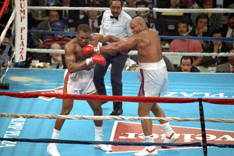 &quot;Ovo je bez ikakve sumnje najveći udarač kojeg je boks ikada vidio! Nokautirao je legende ovog sporta! Nikad nisam vidio takvu snagu na razini na kojoj ju je on pokazivao. Foremanova moć ostaje jedinstvena. Nitko se ne može usporediti s njegovim razornim udarcima&quot;, napisao je Tony Bellew na društvenim mrežama. Na ovoj fotografiji možemo vidjeti meč protiv Evandera Holyfielda. 