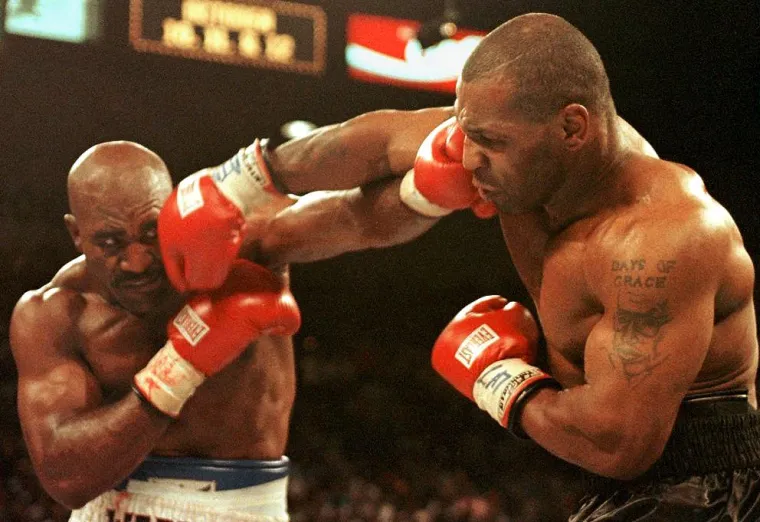 U teškoj kategoriji Evander Holyfield drži jedinstvenu titulu jedinog četverostrukog prvaka u povijesti boksa, što je rekord za koji tvrdi da mu daje prednost nad konsenzusnim najvećim teškašem svih vremena, Muhammadom Alijem. Na ovoj fotografiji možemo vidjeti epski meč Holyfielda i Tysona održanog 29. lipnja 1997. u MGM Grand Areni u Las Vegasu. Holyfield je u tom meču slavio jer su Tysona diskvalificirali u trećoj rundi zbog toga što je ugrizao za uho Holyfielda. 
