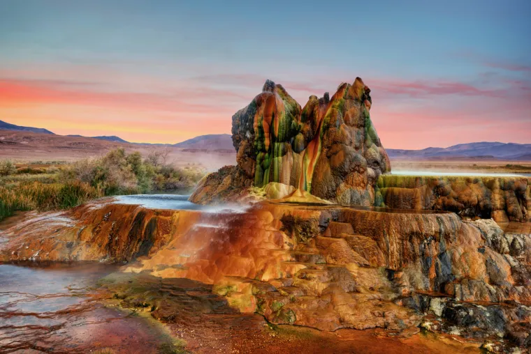 5. Fly Geyser (Sjedinjene Američke Države): Ova nevjerojatna prirodna atrakcija, smještena blizu Nevade, slučajno je nastala 1916. godine tijekom bušenja bunara. Tek su 1960-ih godina, tijekom istraživanja geotermalne energije, znanstvenici primijetili kako je gejzir počeo ispuštati vruću tekućinu, bogatu otopljenim mineralima i bakterijama. Danas su njegove zelene i crvene boje jedno od najimpresivnijih prirodnih okruženja na svijetu. Njegova jedinstvena formacija daje ovom mjestu gotovo nadrealan izgled.