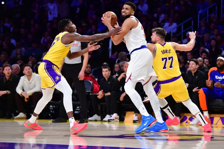 Los Angeles je gubio 90-80 s preostalih 6:57 prije kraja nego što je krenuo u seriju 19-6 i preuzeo prvo vodstvo od početka druge četvrtine. Trica Gabea Vincenta pri preostalih 1:21 do kraja donijela je Lakersima prednost od 99-96 prije nego što su Knicksi izjednačili na 99 nakon Brunsonove igre za tri poena. Karl-Anthony Towns na slici između dva igrača Lakersa. 