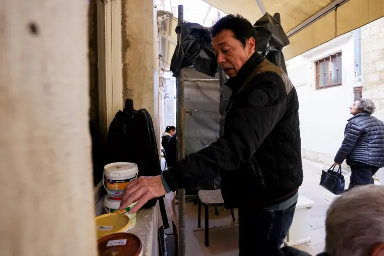 Valentin Radman sa svojim materijalom i alatom. Prolaznici su već u čudu.