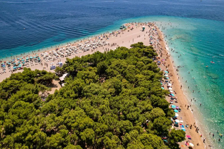 1. Zlatni Rat, otok Brač: Ovo je vjerojatno najpoznatija hrvatska plaža. Njen jedinstveni oblik, koji se mijenja ovisno o vjetru i morskim strujama, čini ju pravim prirodnim fenomenom. Smještena na južnoj strani otoka Brača, u  mjestu Bol, Zlatni Rat je popularno odredište za windsurfere i kitesurfere. Okružena je gustom borovom šumom, koja pruža ugodan hlad, a unutar šume nalaze se ostaci rimske villae rusticae. Do plaže se može doći slikovitom vožnjom trajektom iz Splita. Travel and Leisure redovito uvrštava Zlatni Rat među najbolje plaže u Hrvatskoj. 