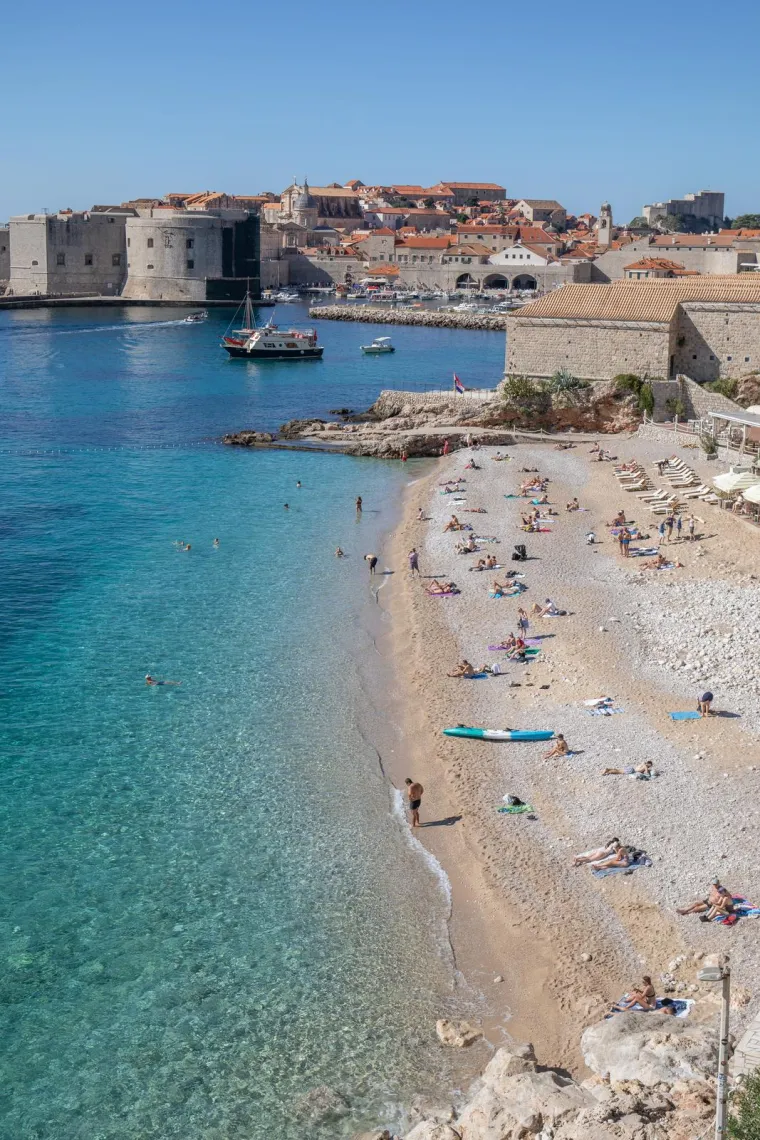 2. Plaža Banje, Dubrovnik: Ovo je najpopularnija je plaža u Dubrovniku, smještena u neposrednoj blizini Starog grada. S plaže se pruža spektakularan pogled na gradske zidine i otok Lokrum. Banje nudi razne vodene sportove i aktivnosti na plaži, kao i brojne restorane i barove. Banje Beach Restaurant, Lounge, and Club popularno je mjesto za turiste, a navečer se pretvara u noćni klub.